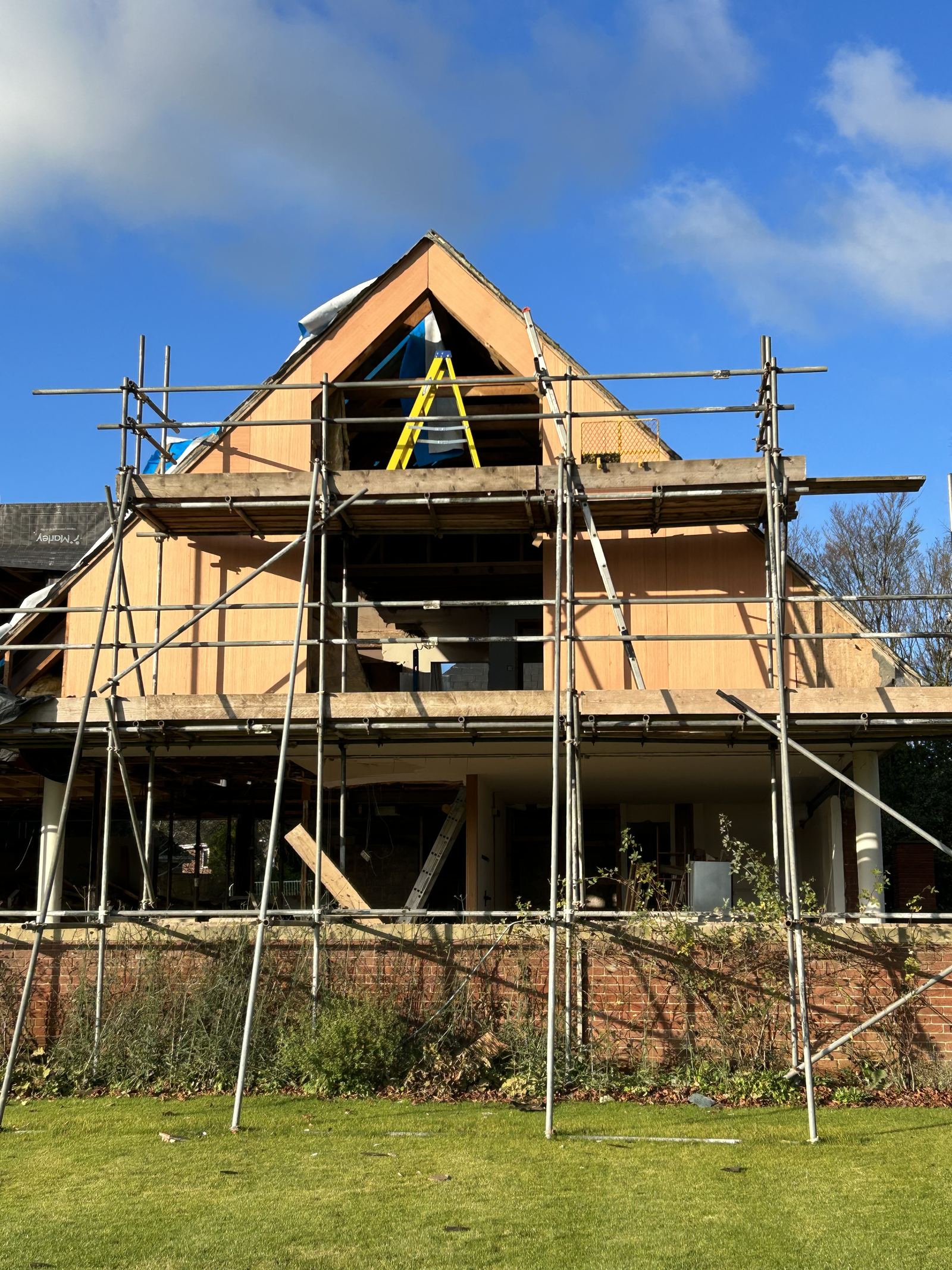 New timber frame gable standing within the scaffold