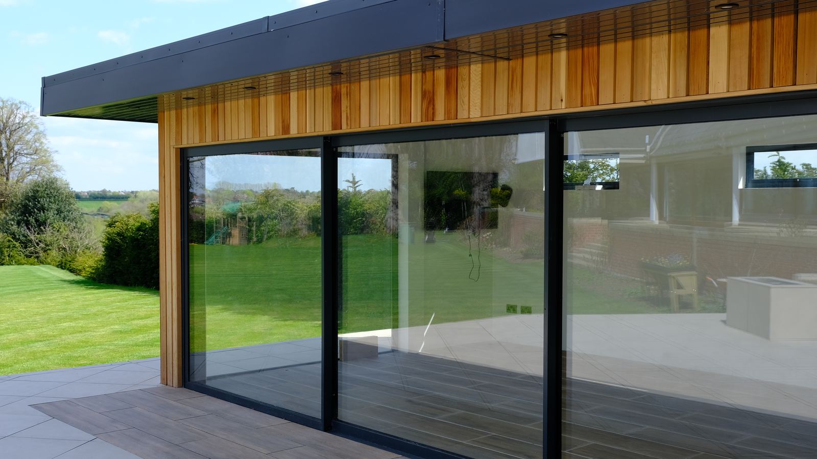 Close view of the cedar soffit, downlights and sliding glazed doors