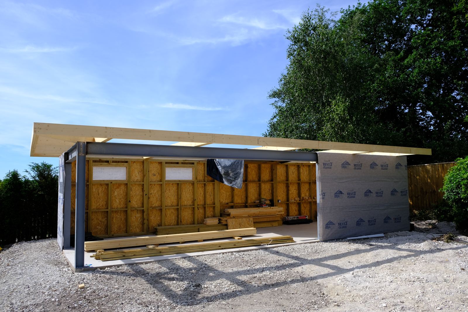 Steel beam supporting timber roof joists over a timber frame building