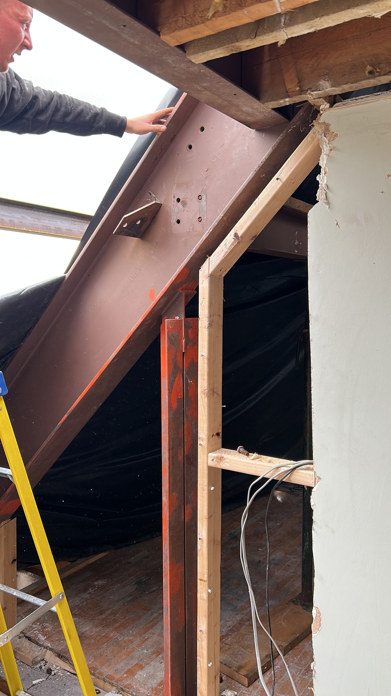 A new steel beam being positioned and checked against the padstone
